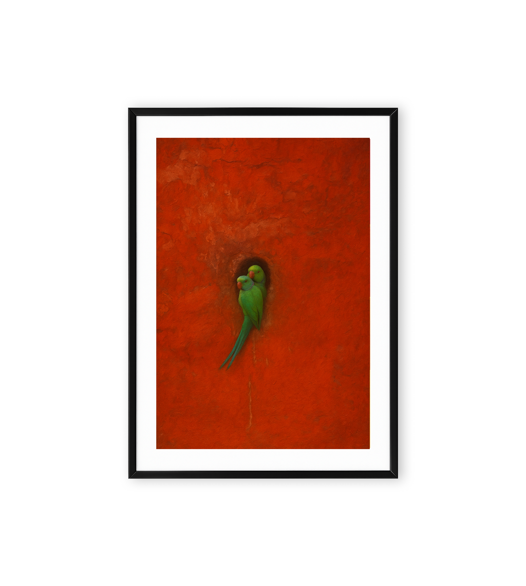 Minimalist wall art of two green parrots resting in a hollow on a vibrant red textured background.